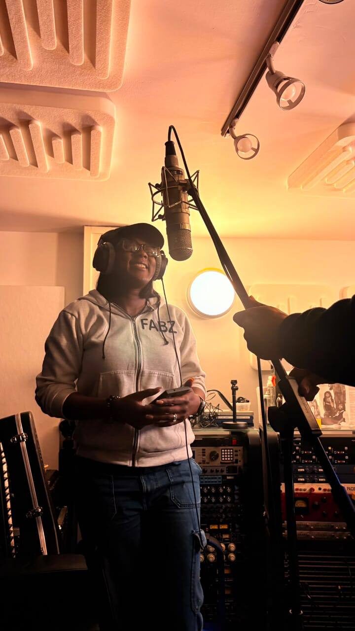 Omowunmi listening back to a take between vocal sessions